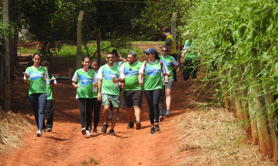 Pessoas fazem caminhada em chão de terra