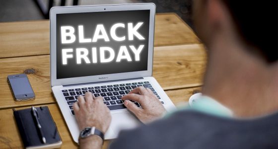 Homem olha para tela de notebook com a frase "Black Friday"