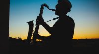 Silhueta De Um Homem Tocando Saxofone Durante O Pôr Do Sol